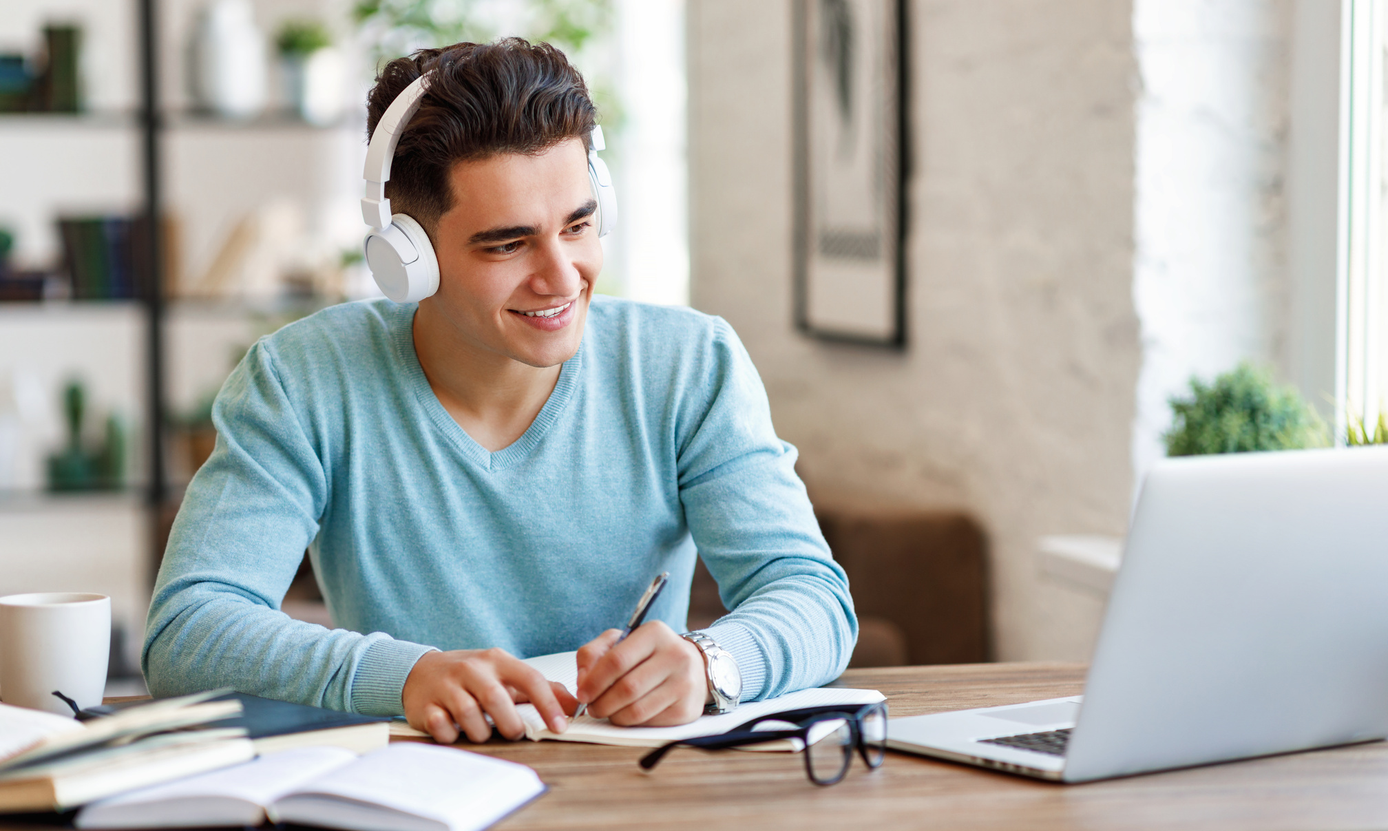 Ethnic student making notes during online lesson