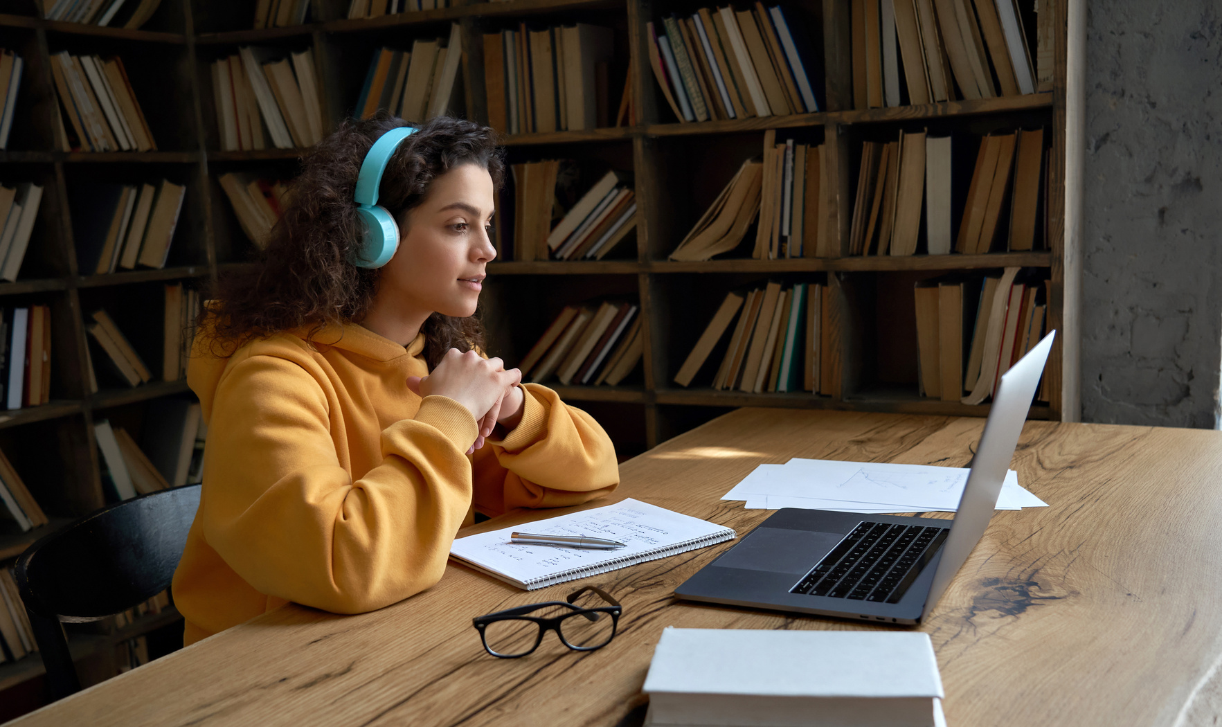 Student with Headphones Watching Online Webinar on Laptop