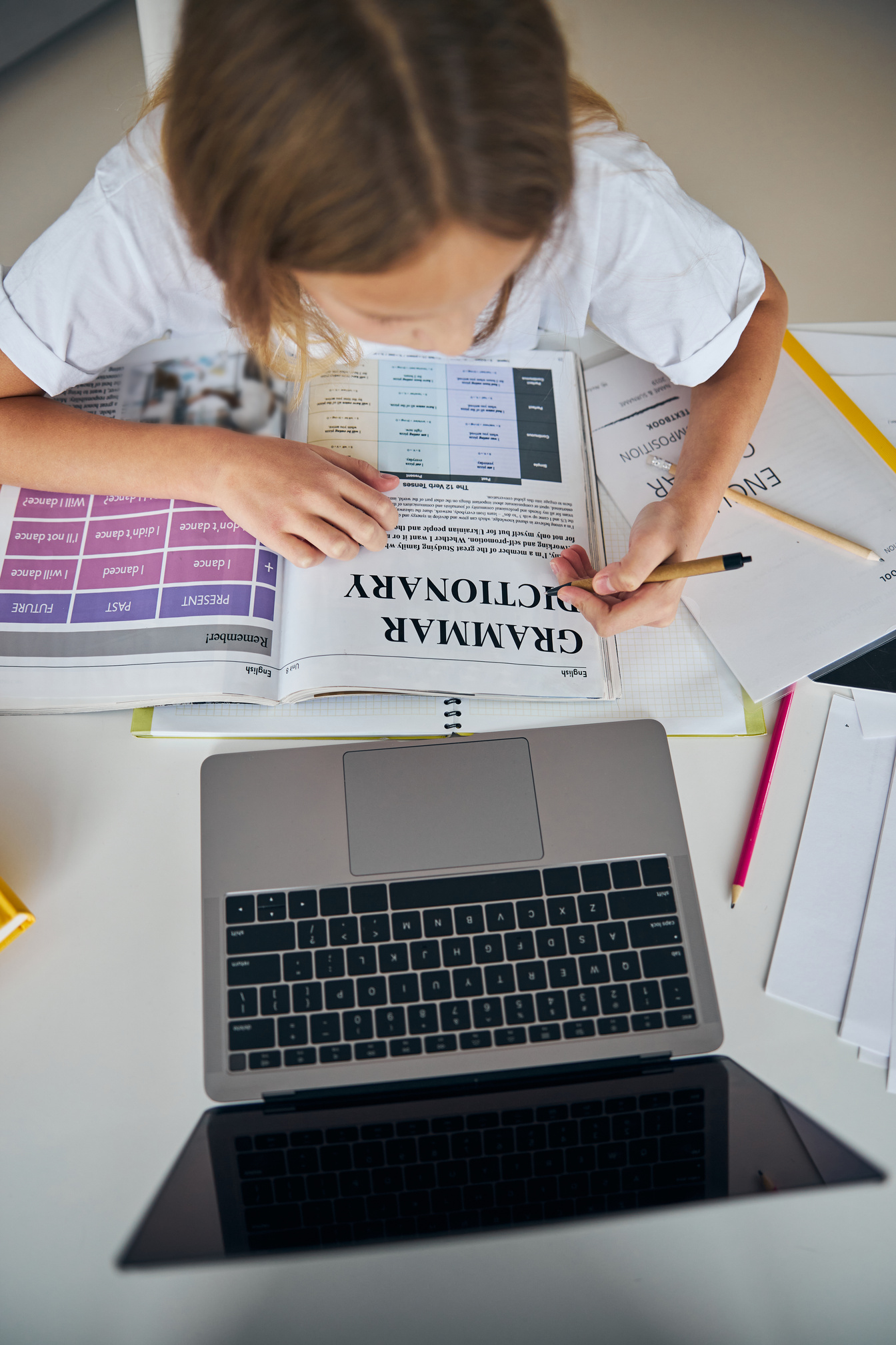 Schoolgirl with an eco-pen is studying grammar